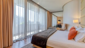 Una habitación de hotel moderna con una cama grande, un escritorio y una silla.
