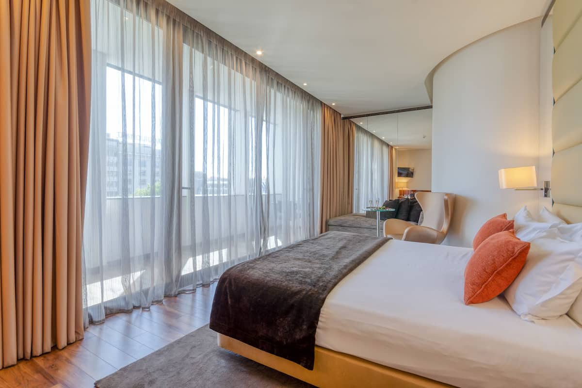 Ein modernes Hotelzimmer mit einem großen Bett, einem Schreibtisch und einem Stuhl.