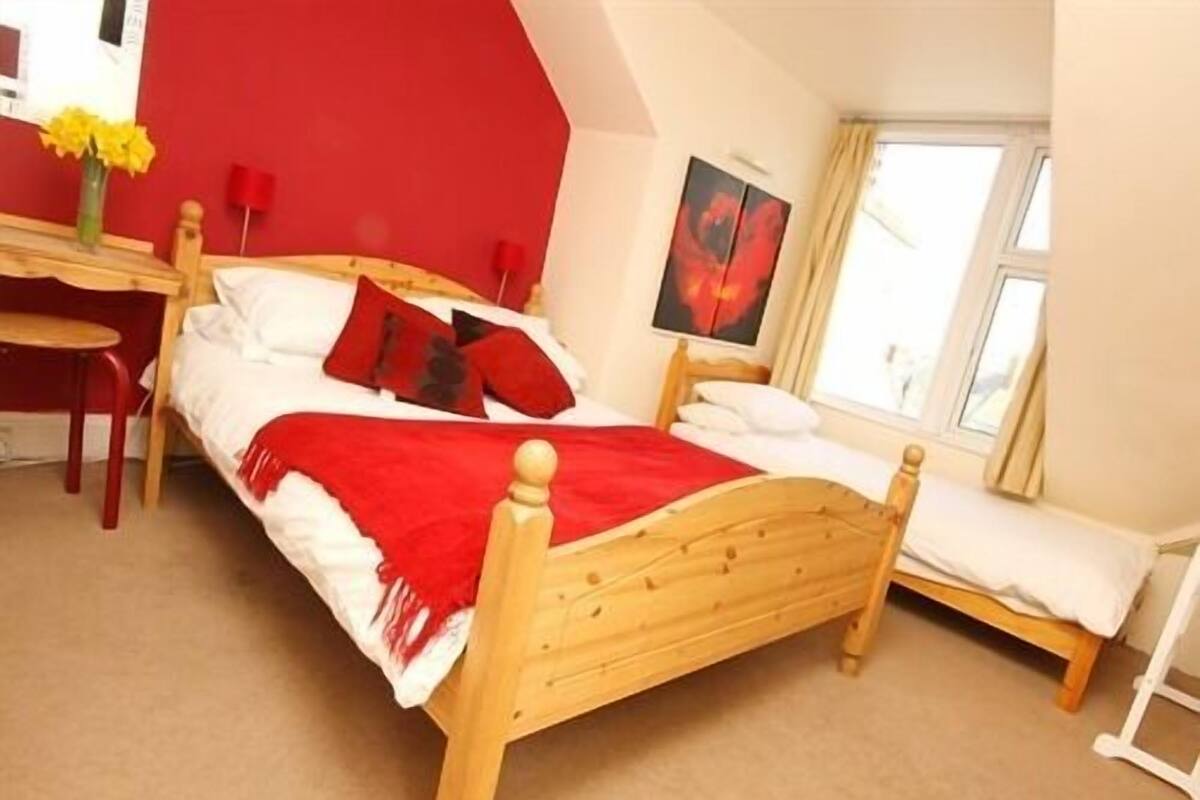 A bedroom with a wooden bed, a desk, and a chair.