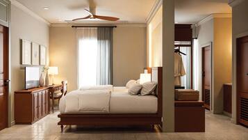 A spacious bedroom with a large bed, a desk with a lamp, a wardrobe, and a ceiling fan.