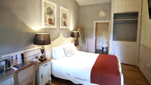 Un dormitorio con cama, mesita de noche, lámpara, silla y armario.