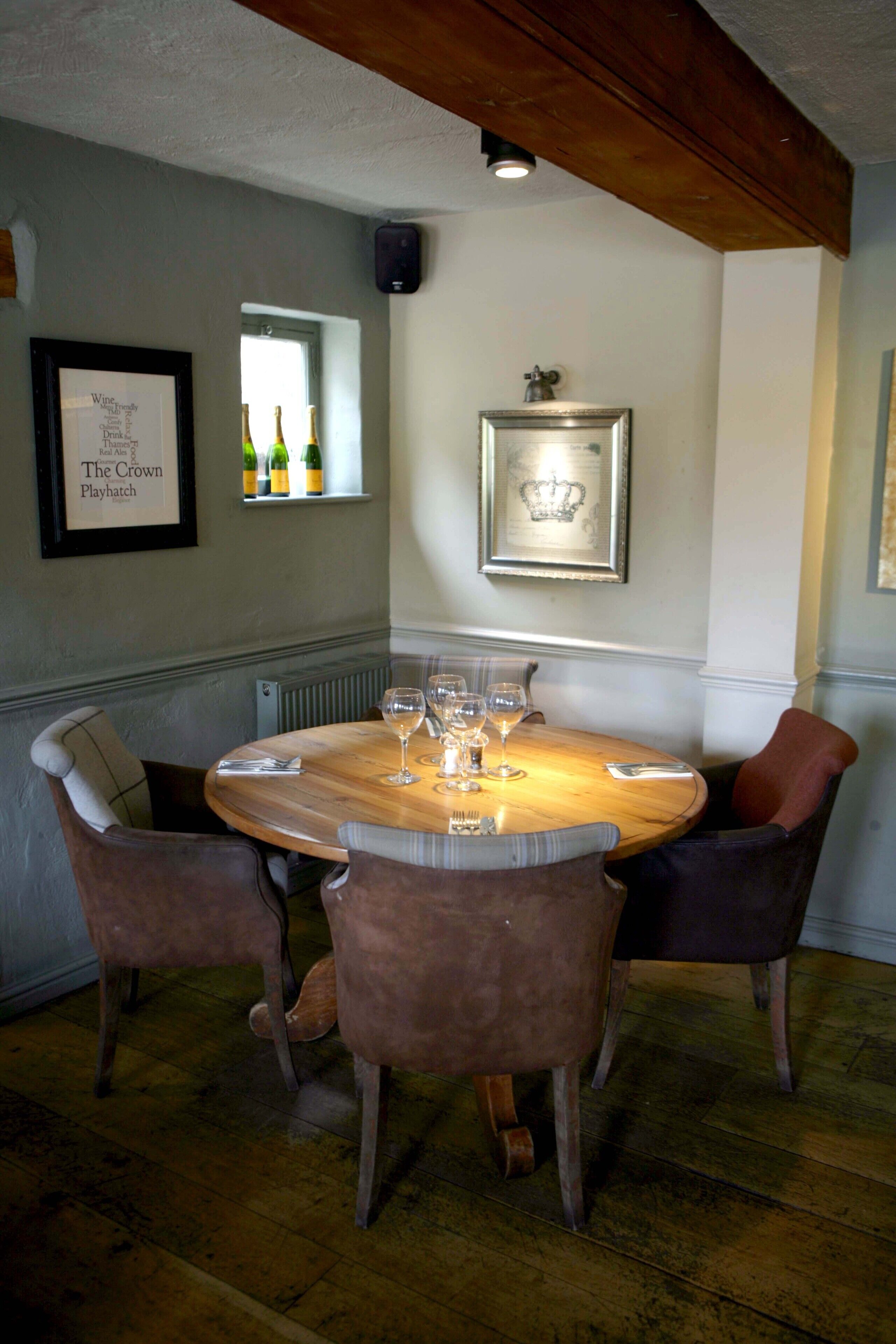 A dining area with a wooden table set for six, surrounded by upholstered chairs.