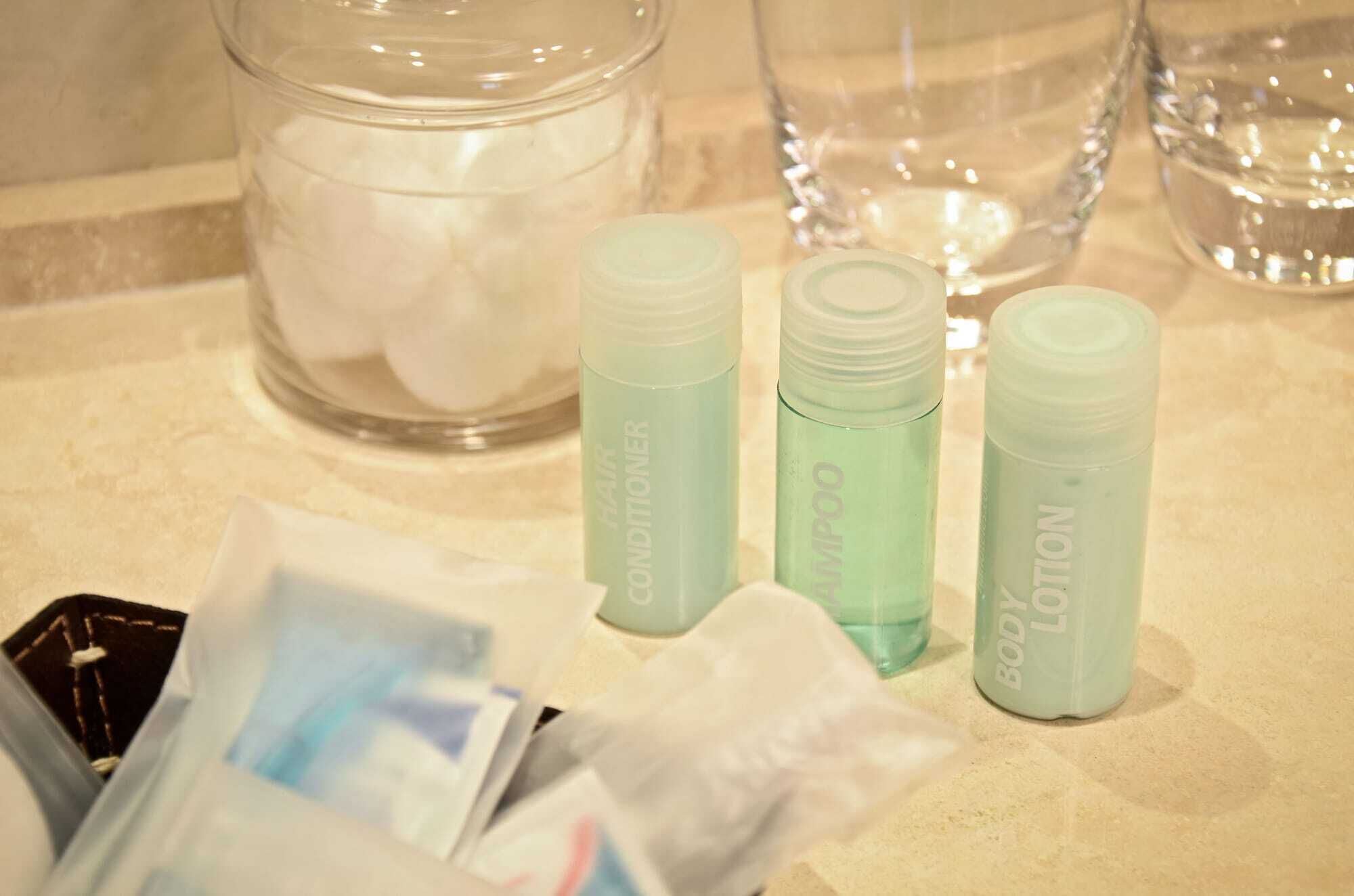 Een badkamermeubel met toiletartikelen, waaronder haarkonditioneer, shampoo en lotion.