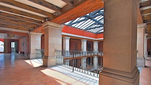 A spacious atrium with high ceilings, large columns, and a glass railing overlooking a lower level. - Casa Primavera Hotel Boutique & Spa (San Miguel de Allende)