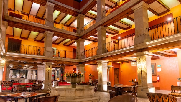 A multi-level interior with a central atrium, wooden beams, and a glass ceiling. - Casa Primavera Hotel Boutique & Spa (San Miguel de Allende)