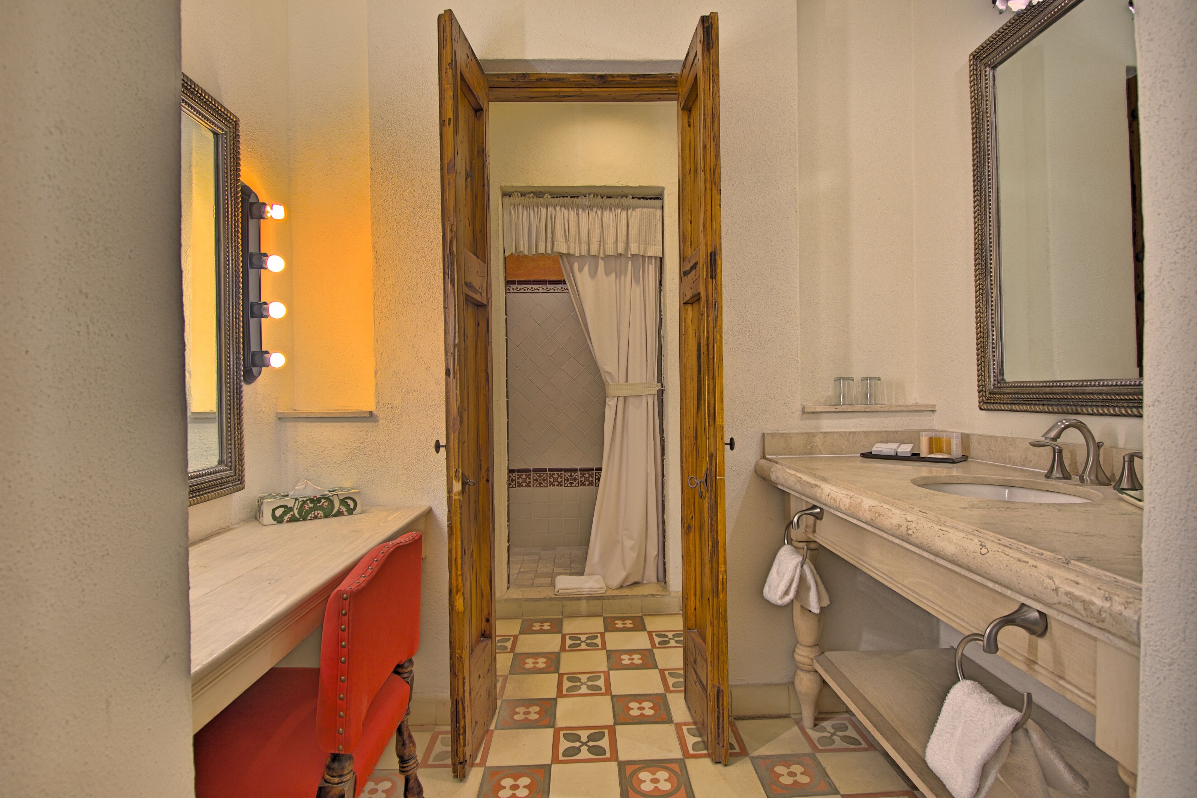 Een badkamer met een wastafel, een spiegel en een douche.
