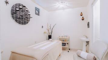 Experience comfort in this serene room featuring a neatly made bed, a bedside table, and a potted plant.