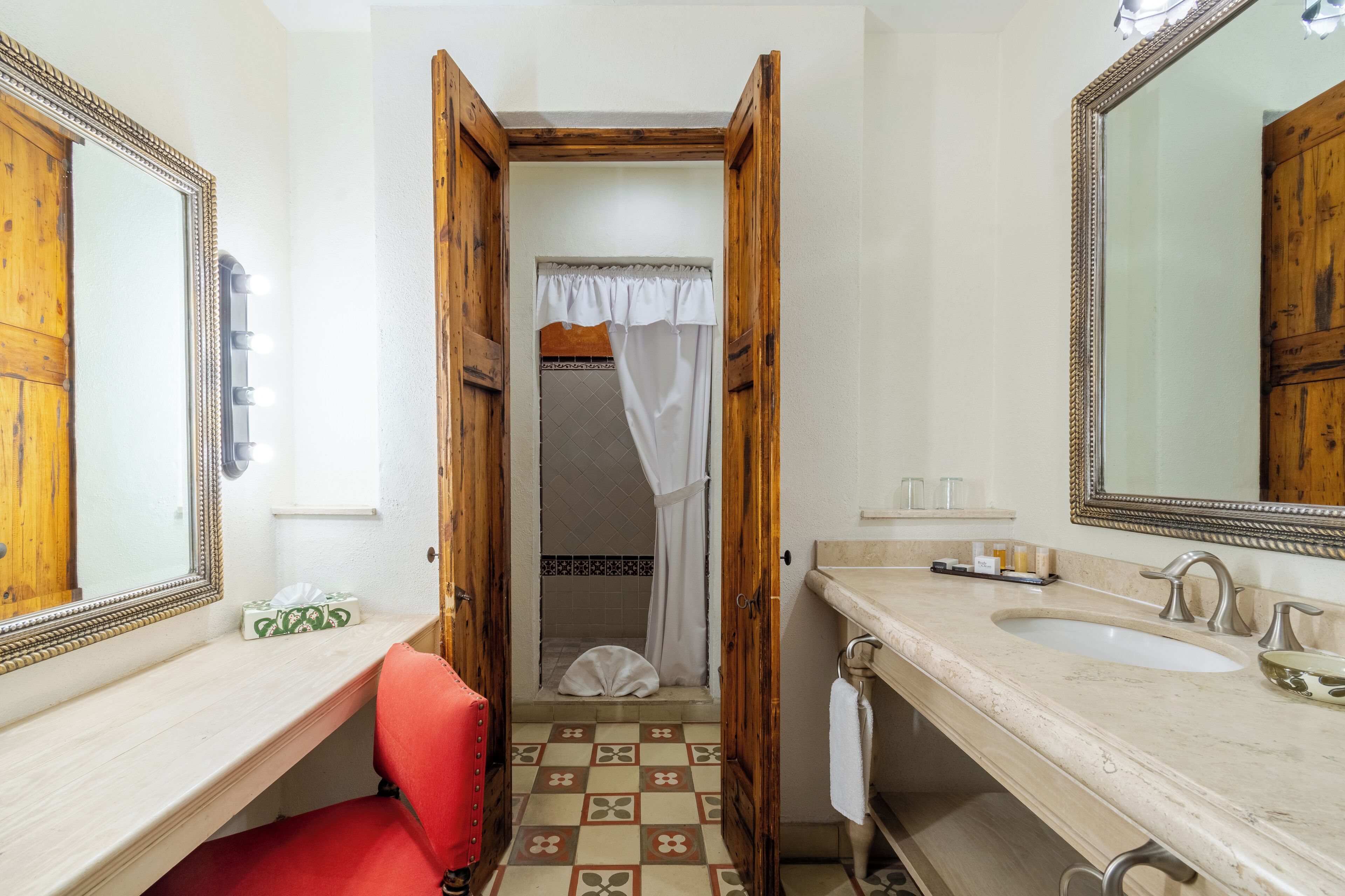 A bathroom with a vanity, a large mirror, and a shower area.