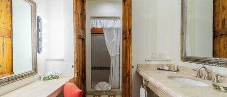 A bathroom with a vanity, a large mirror, and a shower area.
