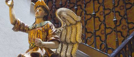 Una escalera con una estatua decorativa de un ángel en la parte superior.
