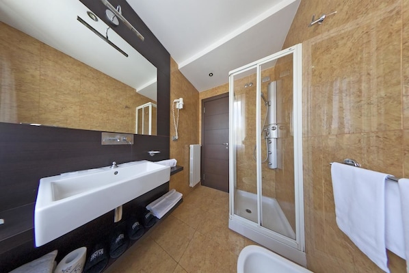 A modern bathroom with a large sink, a shower enclosure, and a toilet. - Inverigo Hotel (Inverigo)