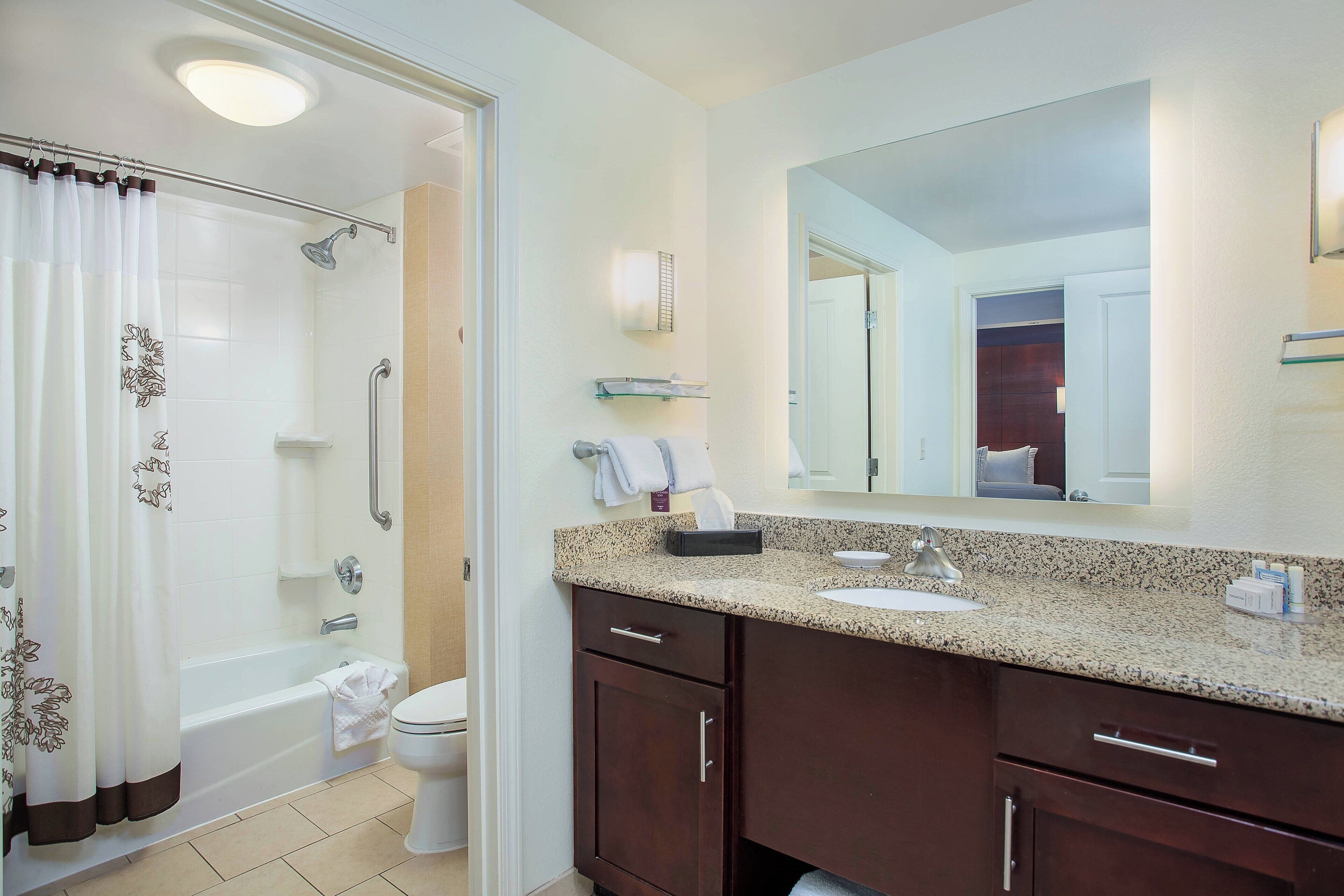 A modern bathroom with a shower, toilet, and vanity.