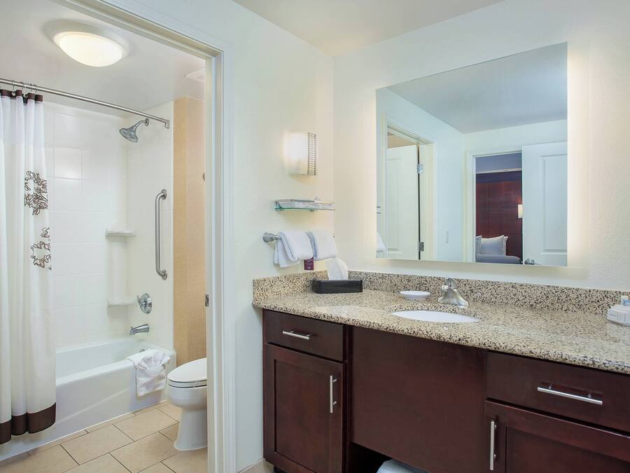 A modern bathroom with a shower, toilet, and vanity.
