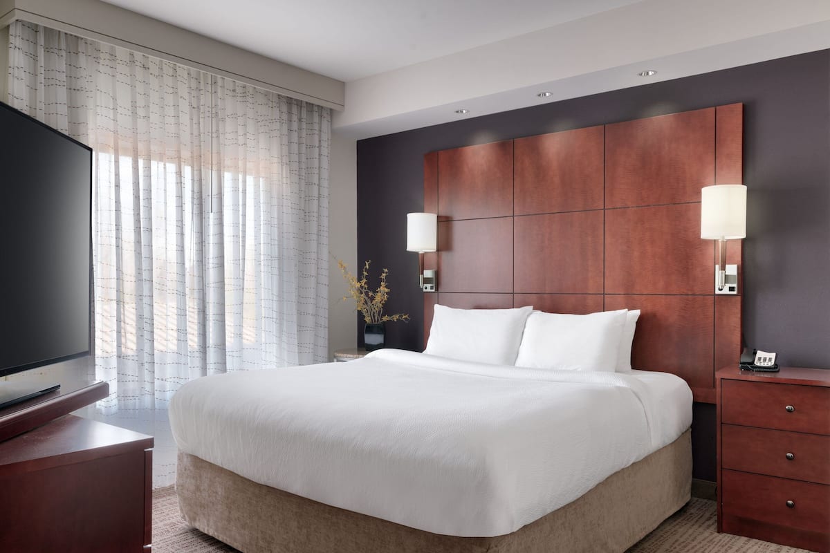 Escritorio, cortinas blackout y tabla de planchar con plancha