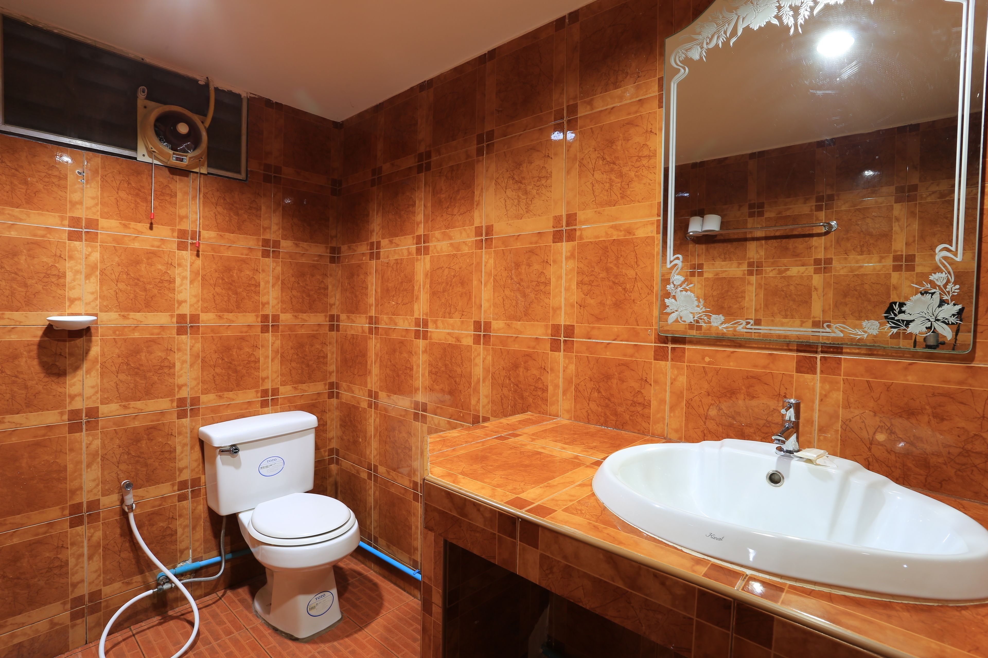 A bathroom with a toilet, sink, and mirror.