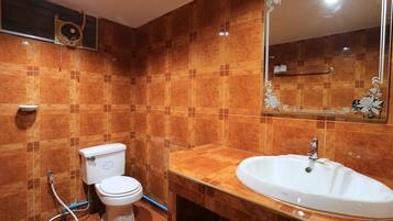 A bathroom with a toilet, sink, and mirror.