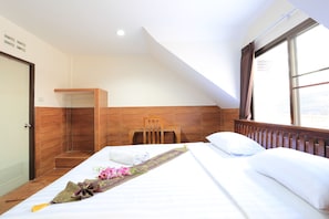 A hotel room with a bed, a wooden chair, a desk, and a window. - The Siam Guest House (Pattaya)