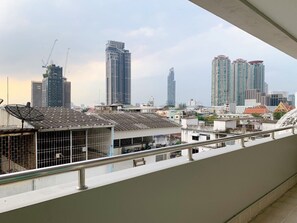 A cityscape with high-rise buildings, including a distinctive skyscraper with a unique design. - Miloft Sathorn hotel (Bangkok)