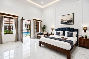 A spacious bedroom with a large bed, a view of a swimming pool, and a modern design. - Leoney Resort (Vagator)
