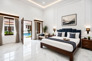 A spacious bedroom with a large bed, a view of a swimming pool, and a modern design.