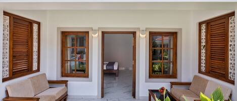 A room with a sofa, a bed, and a wooden door with decorative panels.