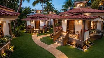 A property with multiple villas, each featuring a tiled roof, a front porch, and a staircase leading to the entrance.