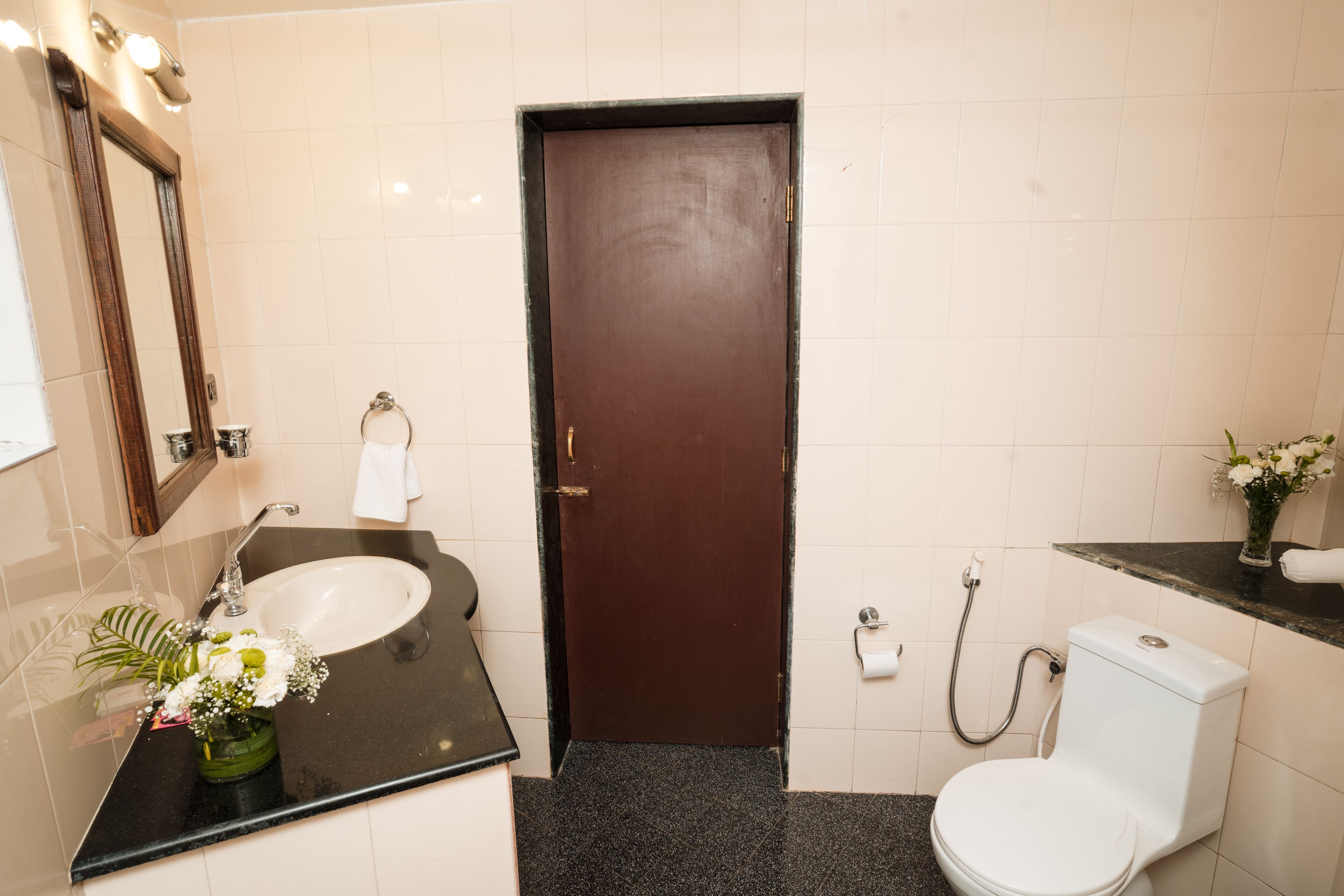 Un baño con lavamanos, espejo, inodoro y ducha.