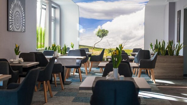 A modern meeting room with a large window, a view of the sky, and indoor plants. - Hotel Horyzont (Rzeszów)