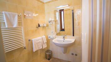 A bathroom with a sink, mirror, towel rack, and a trash bin.