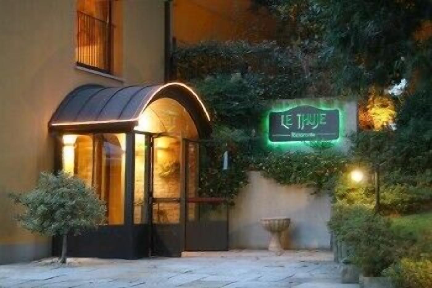 A cozy, well-lit outdoor seating area with a neon sign reading "LE THUIRE" and a small, enclosed structure with a curved roof.