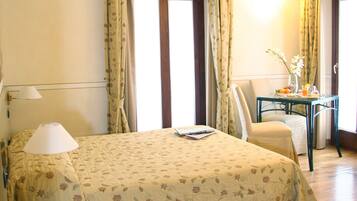 Une chambre d’hôtel équipée d’un lit, d’un bureau, d’une chaise, d’une lampe et d’un téléphone.