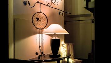 A staircase with a modern design, a wall-mounted dreamcatcher, and a table with a lamp and decorative items.