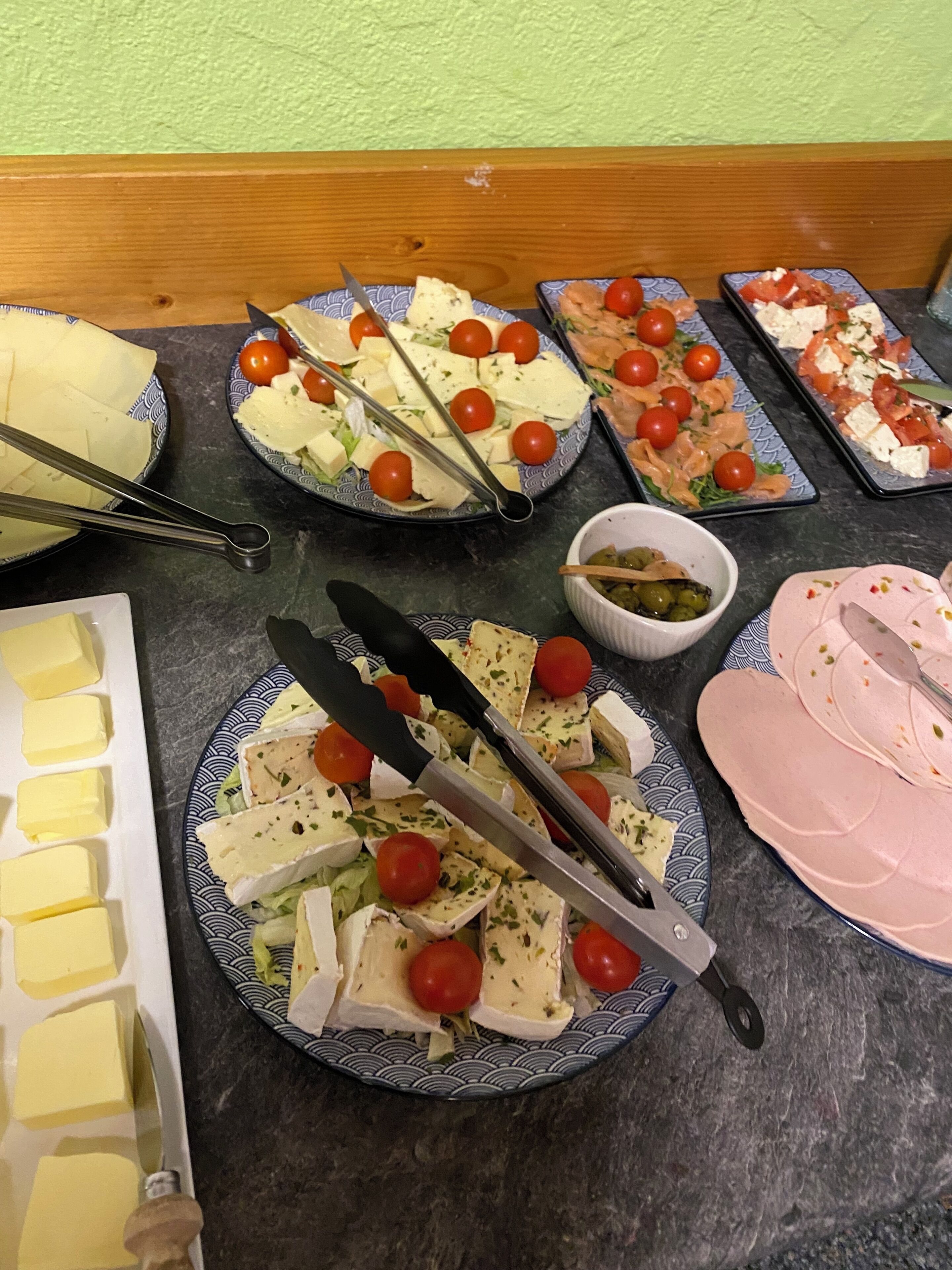 Ein Tisch mit verschiedenen Speisen, darunter Käse, Tomaten und Oliven.