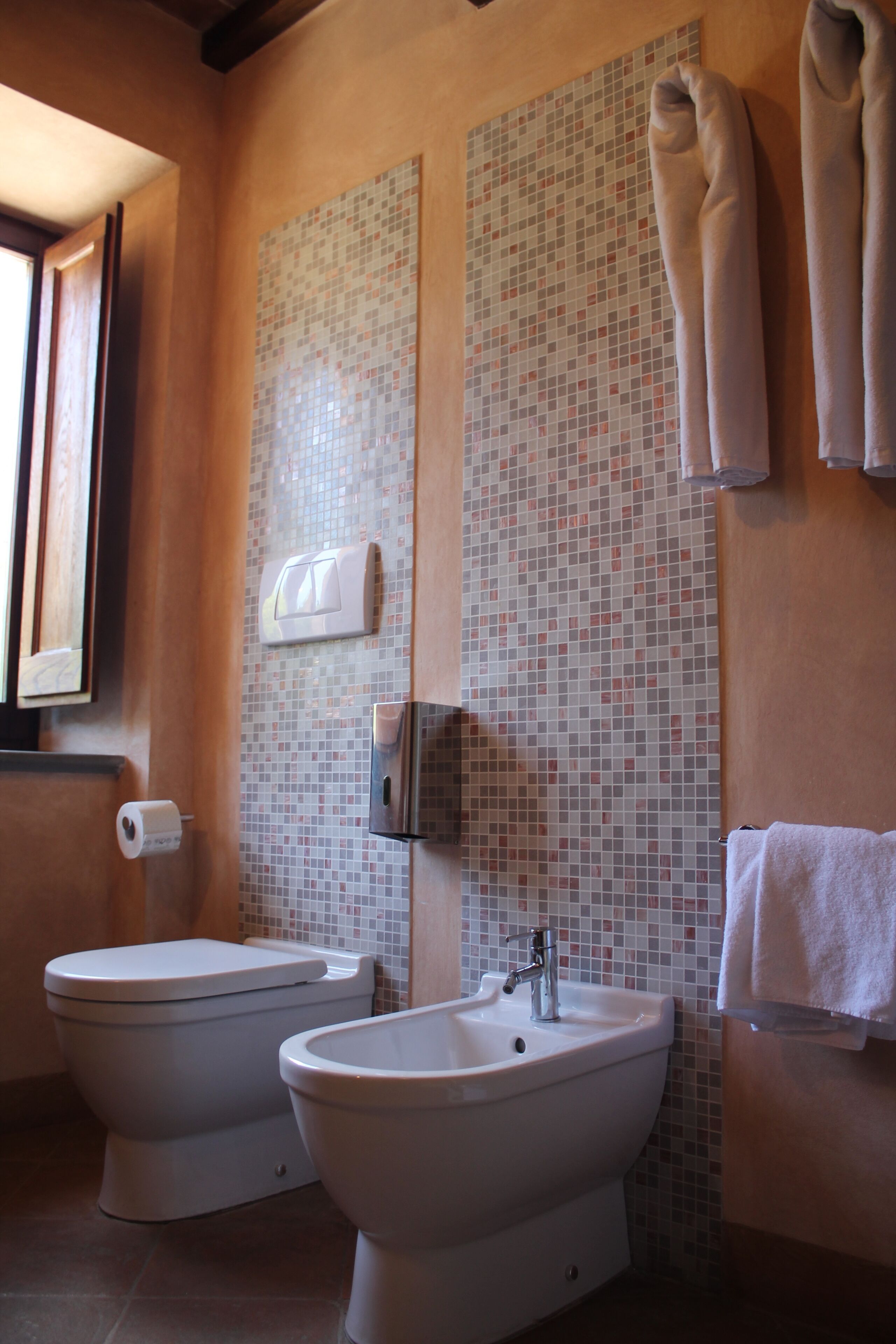 Un baño con dos inodoros, un lavamanos y un espejo.