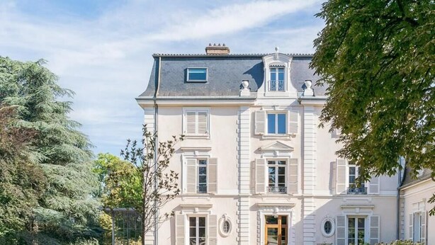 A large, two-story building with a symmetrical facade, multiple windows with shutters, and a central entrance with a door. - Valpré Lyon Hôtel (Ecully)