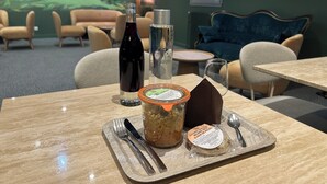 A dining table with a bottle, a jar, a cookie, and a napkin. - Valpré Lyon Hôtel (Ecully)