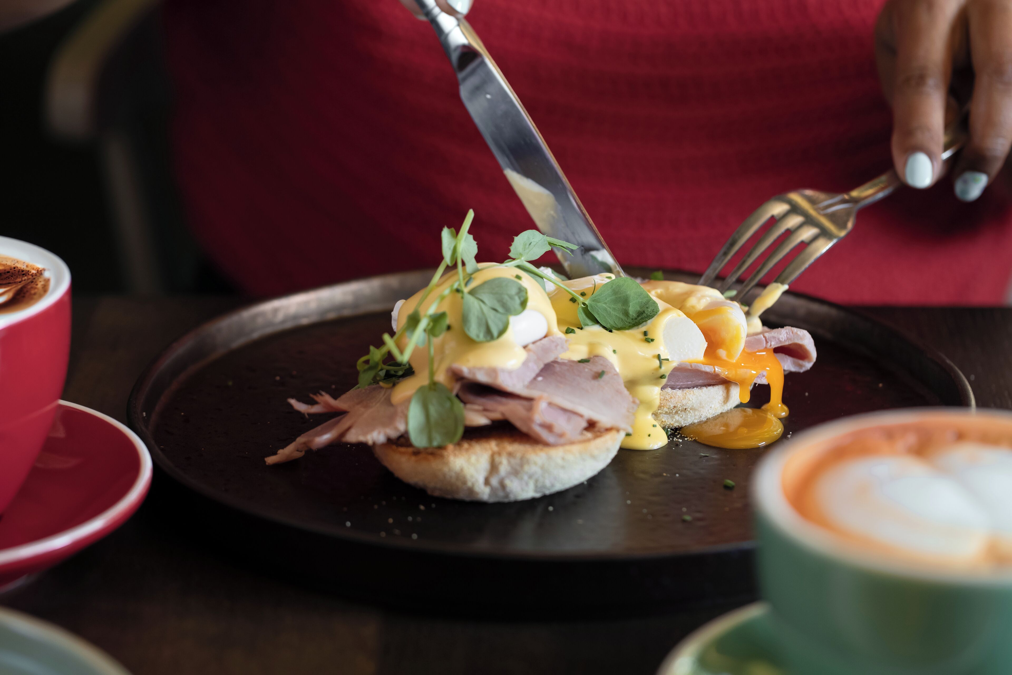 A breakfast dish with eggs, ham, and greens on a plate.