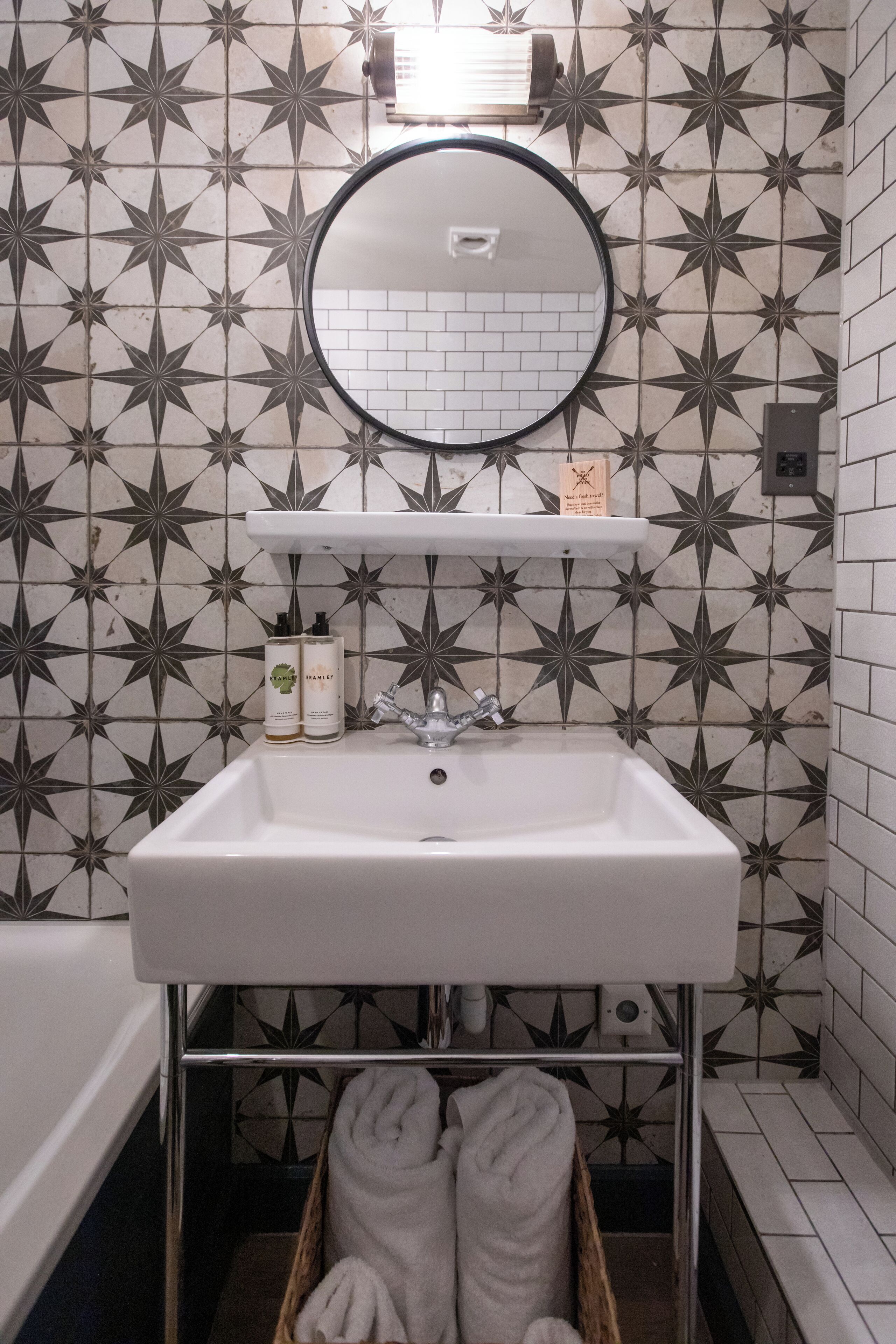 A bathroom with a white sink, a mirror, and a towel rack.