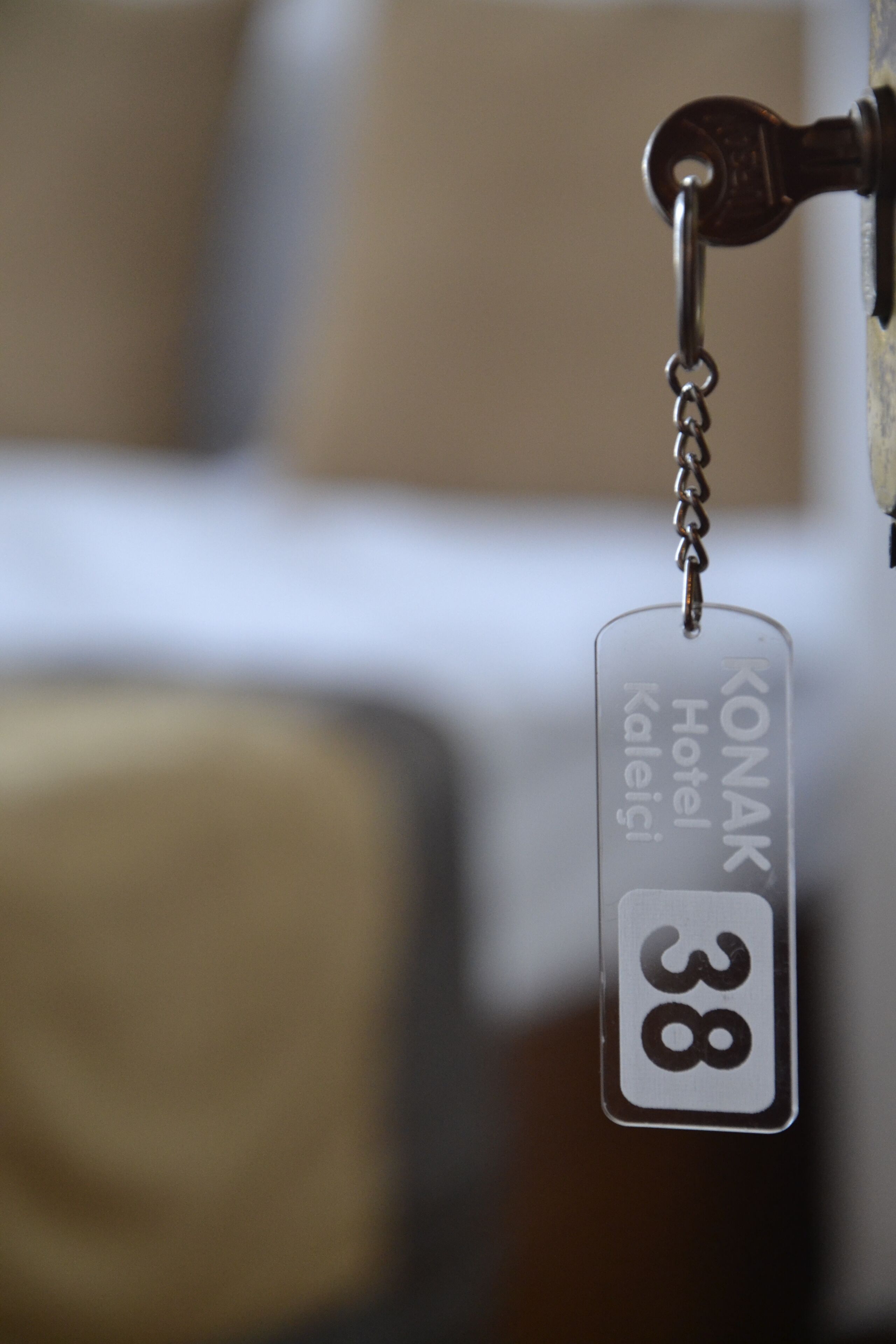 Een sleutelhanger met de tekst 'KONAK Hotel Kaleigi 38' en het nummer '38'.