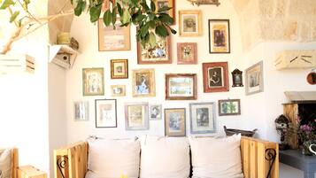 A cozy room with a wooden bench, a vase of yellow flowers, and a wall adorned with framed pictures.