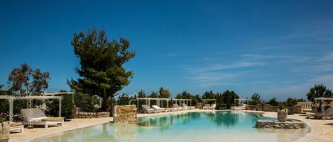 A pool area with lounge chairs and a pergola structure.