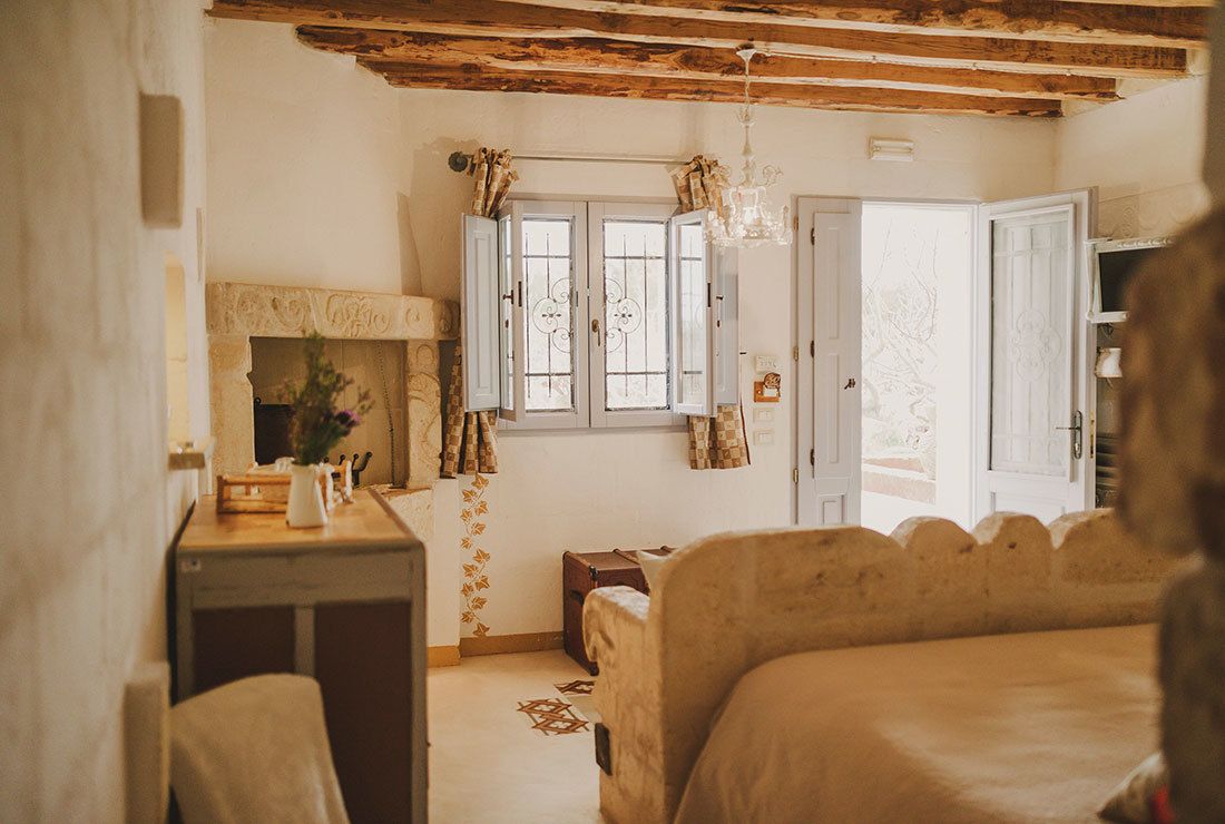 Een knus slaapkamer met een bed, een bureau en een raam met gordijnen.
