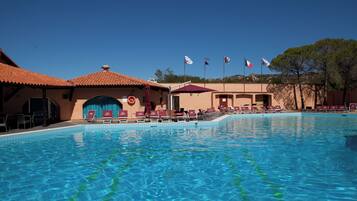 Een buitenzwembad en ligstoelen