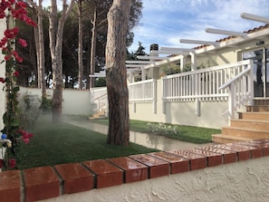 A residential area with a white fence, a brick pathway, and a grassy lawn. - Club Esse Cala Bitta (Arzachena)