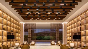 A modern lobby with a wooden ceiling, comfortable seating, and a large TV screen. - Hotel Irotama Lago (Santa Marta)