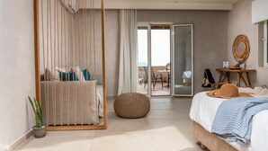 Un dormitorio moderno con cama, una silla colgante, una mesita con fruta y vistas al exterior.