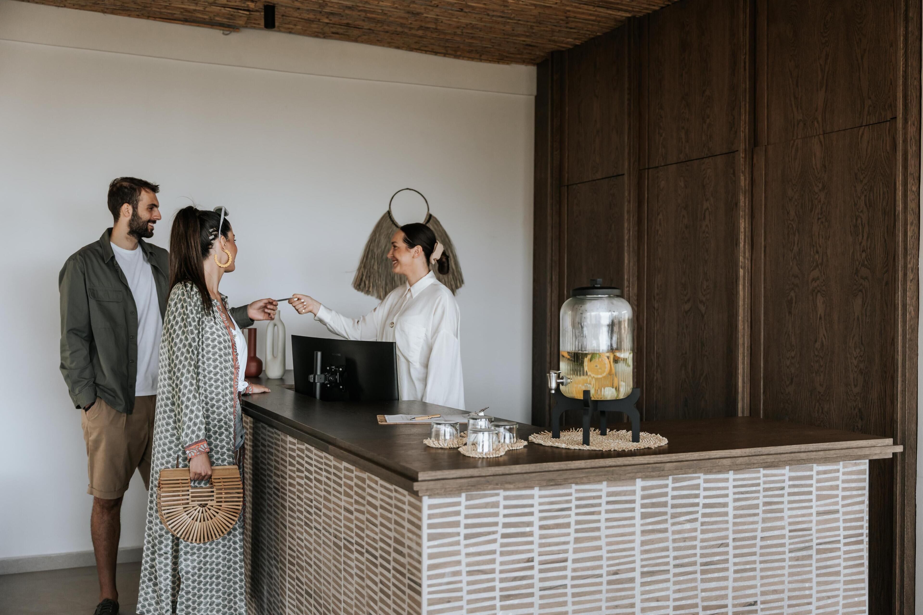 A reception area with a wooden counter, a coffee machine, and a decorative glass container.