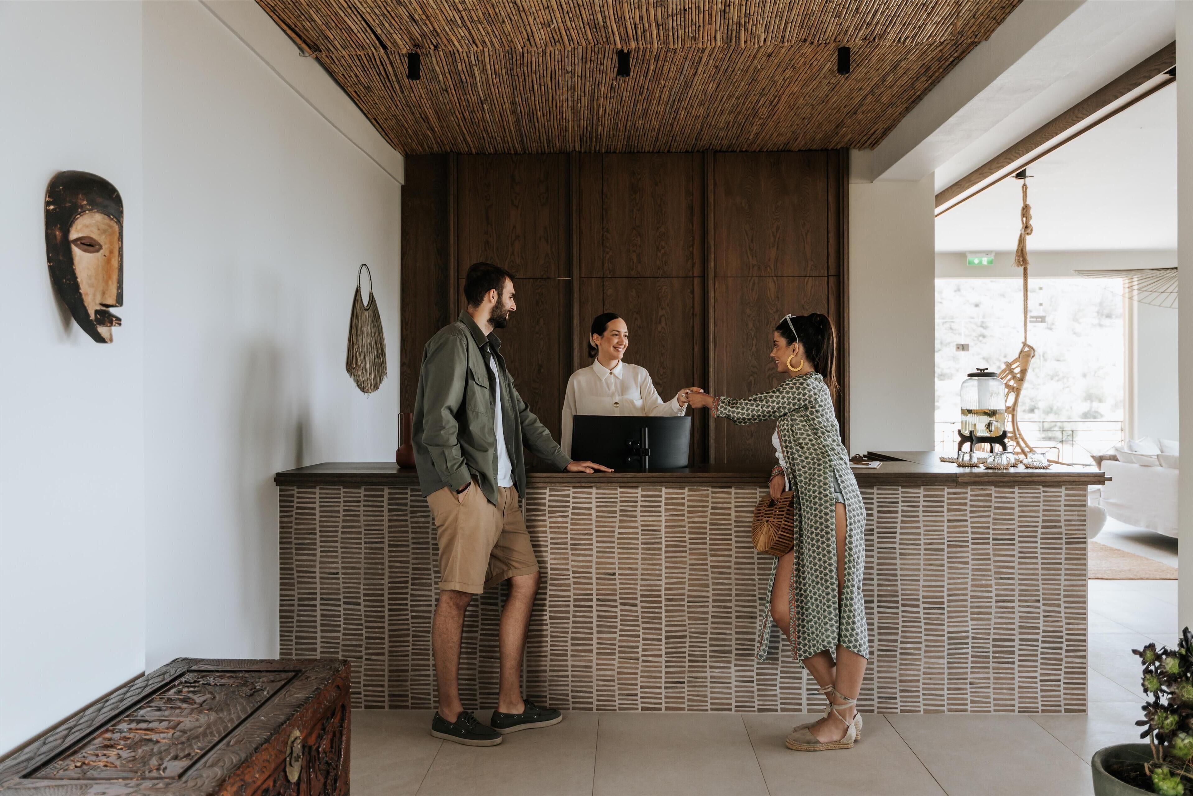 A reception area with a wooden counter, a woven ceiling, and a large window.