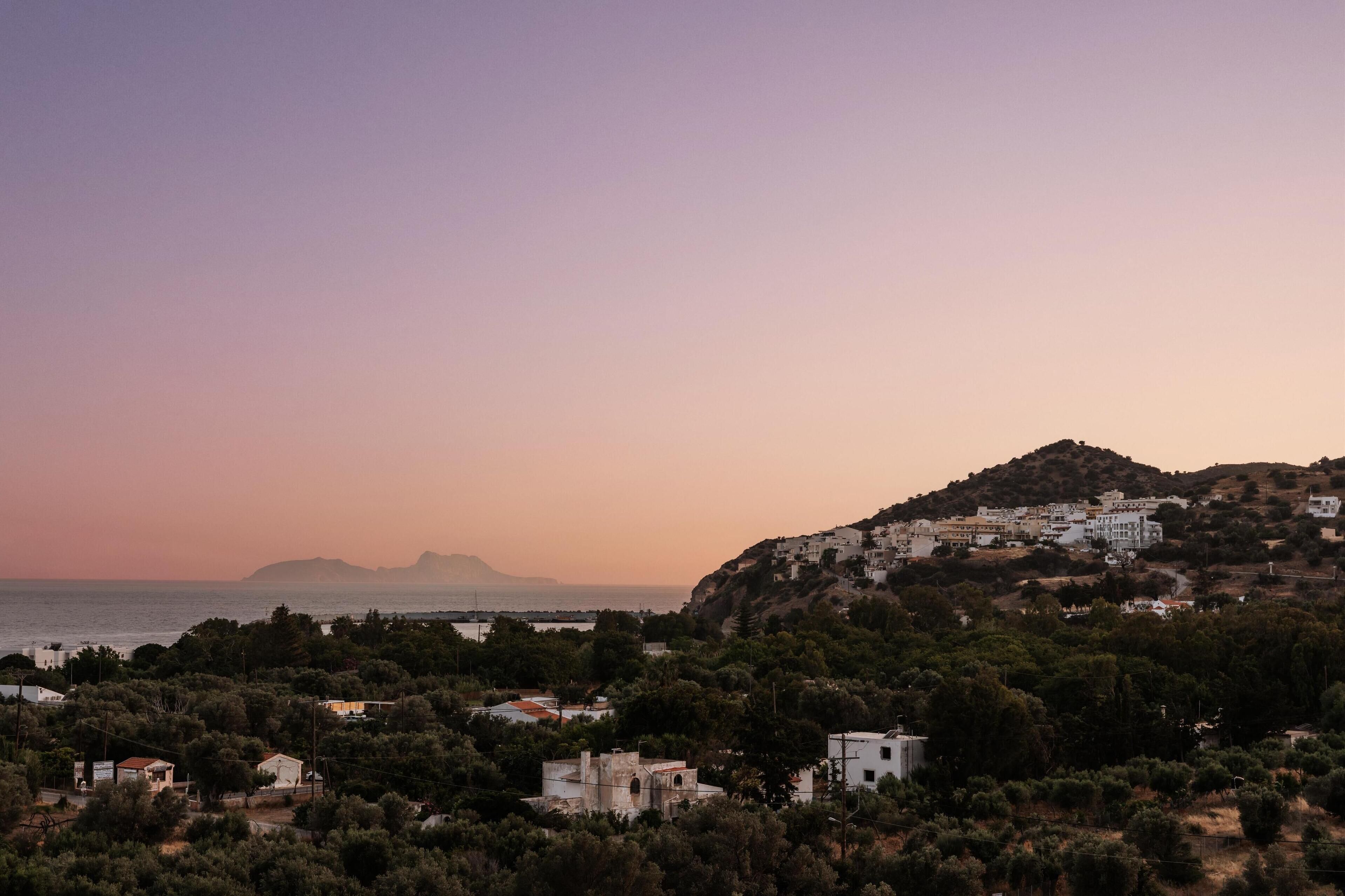 A coastal town with buildings on a hillside, overlooking the sea.