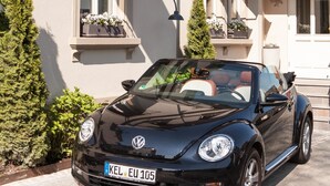 A black Volkswagen convertible parked in front of a building with a sign reading "Hotel & Wirtshaus." - DORMERO Hotel Kehl (Kehl)